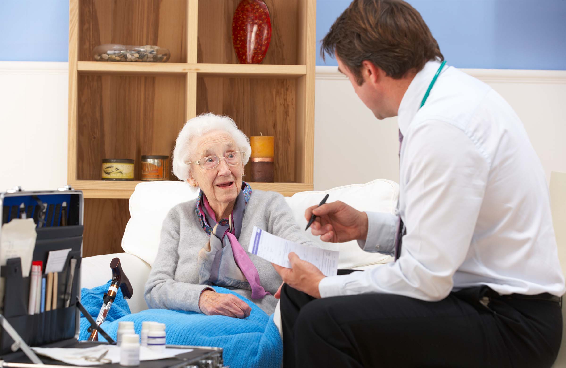 A doctor visiting an older patient in her home.