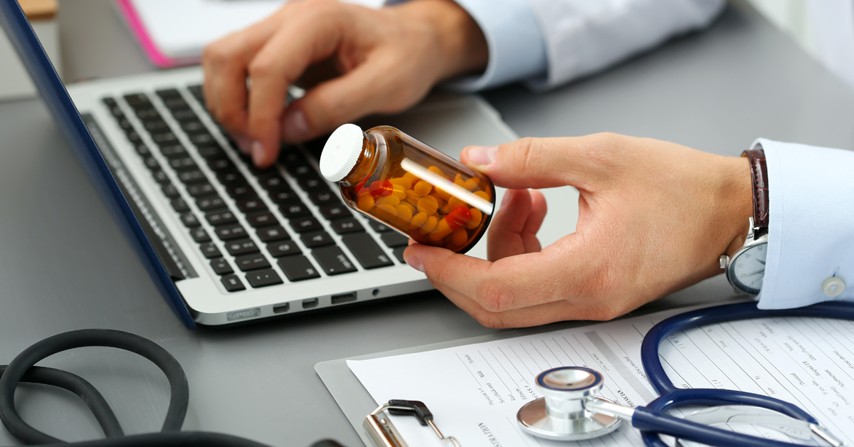 A GP entering electronic prescribing details into a computer.