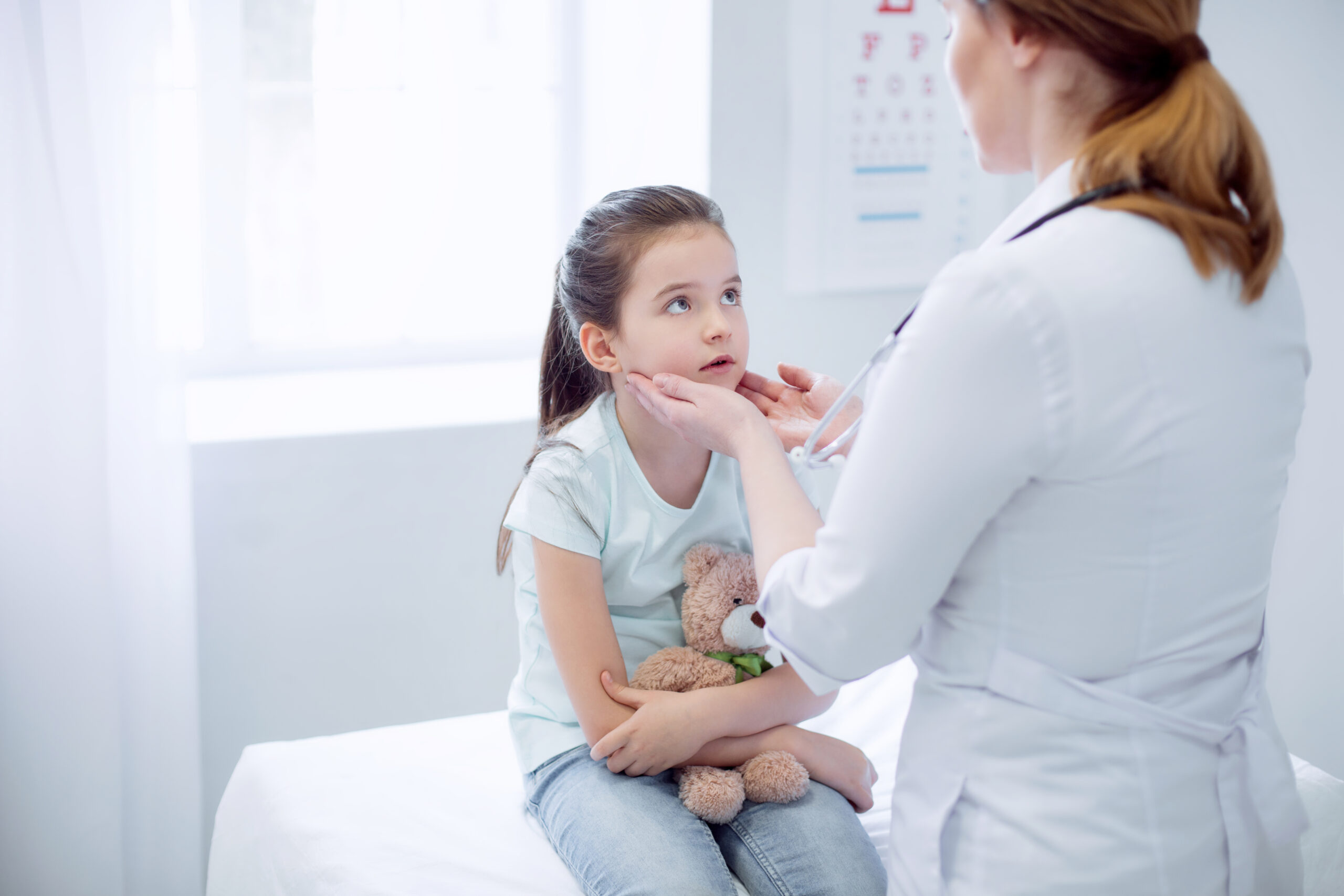 A young girl being assessed by her GP.