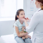 Image of child being examined by doctor, for strep.