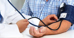 A person having their blood pressure checked by their GP.