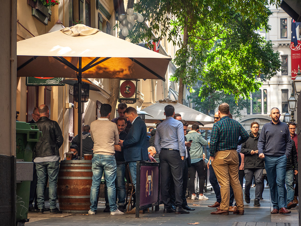 People socialising and drinking alcohol outside a pub in Melbourne, Australia.