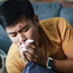 A person coughing with the flu/seasonal influenza.