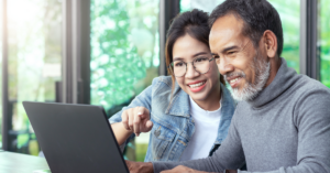 A care finder supporting an older person using a laptop to navigate potential aged care services.