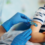 Doctor putting band aid on child after immunisation
