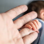 asian newborn baby holding parent hand grab finger.