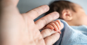 asian newborn baby holding parent hand grab finger.