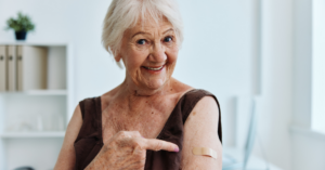 Older lady pointing to a band aid after vaccine