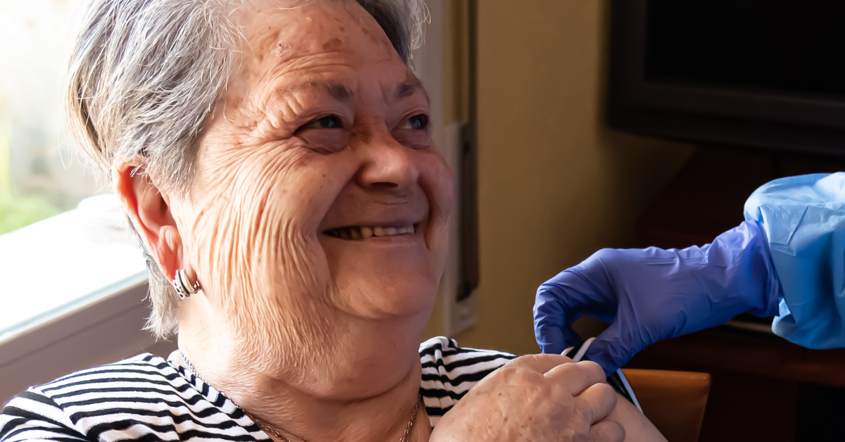 Older woman having a covid vaccine at home