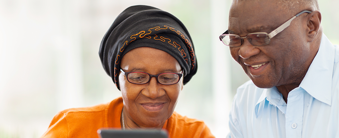 An elderly couple look at a tablet together