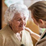 Female doctor visits a senior woman during visit to a residential aged care home