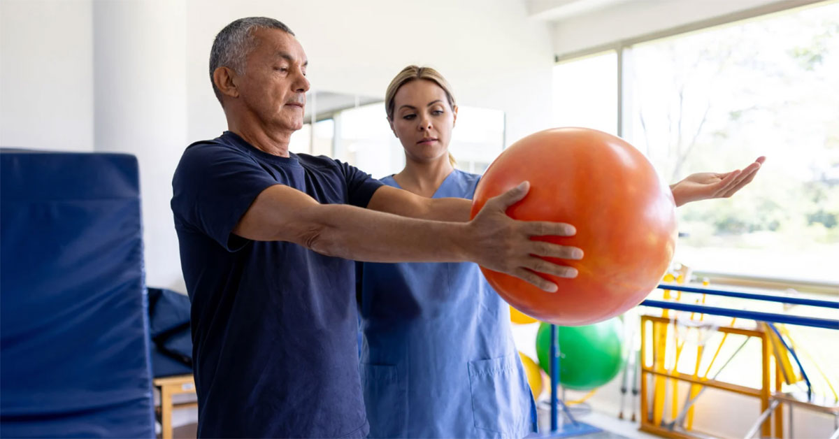 A female nurse performs physical therapy exercises with a male patient
