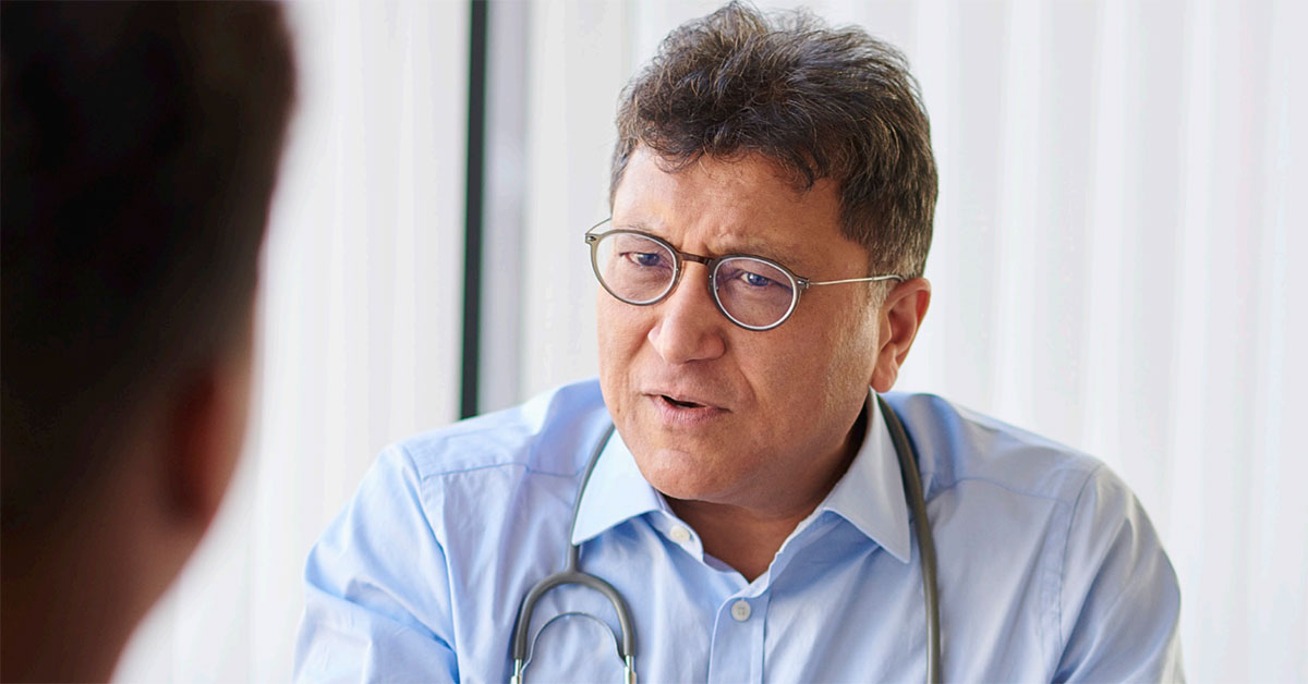 A male general practitioner speaks with a patient about lung cancer screen