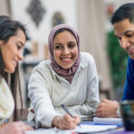 A diverse group of adults discuss new health ideas and put their thoughts down on paper