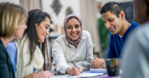 A diverse group of adults discuss new health ideas and put their thoughts down on paper
