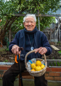 Italo poses with a basket of lemons in his Thornbury home