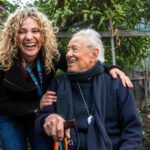 94-year-old Italo poses for a photo with carer Penny at his Thornbury home