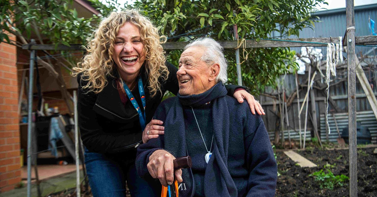 94-year-old Italo poses for a photo with carer Penny at his Thornbury home