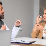 A male general practitioner speaks with a female patient about a new asthma inhaler
