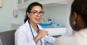 A female general practitioner speaks with a middle-aged woman patient about menopause