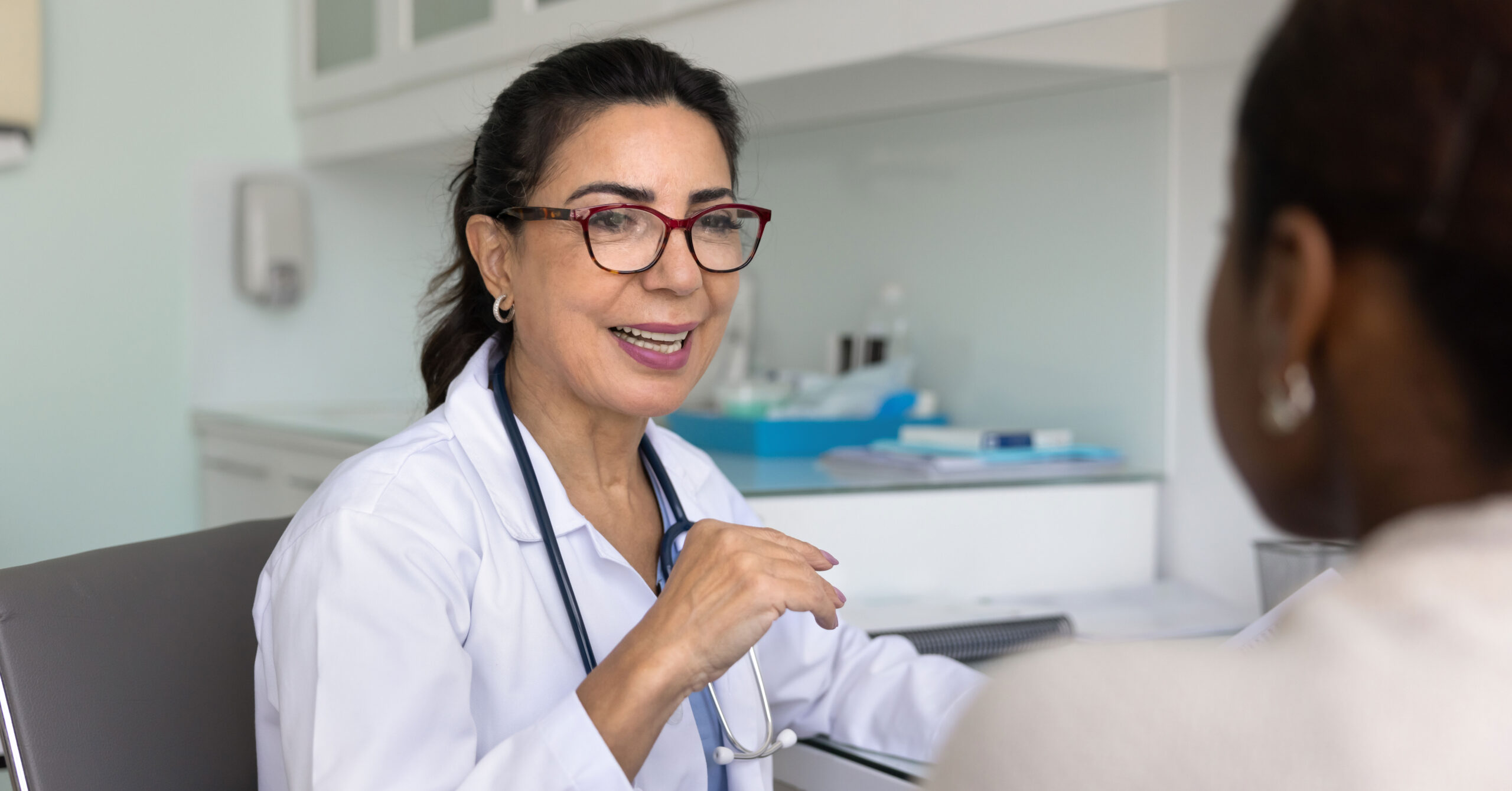 A female general practitioner speaks with a middle-aged woman patient about menopause