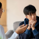 A young man speaks with a mental health professional