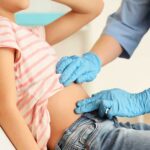 Female doctor examining teenage girl with appendicitis in clinic, closeup
