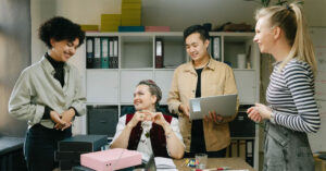 A multidisciplinary care team chat in the staff area of a general practice.