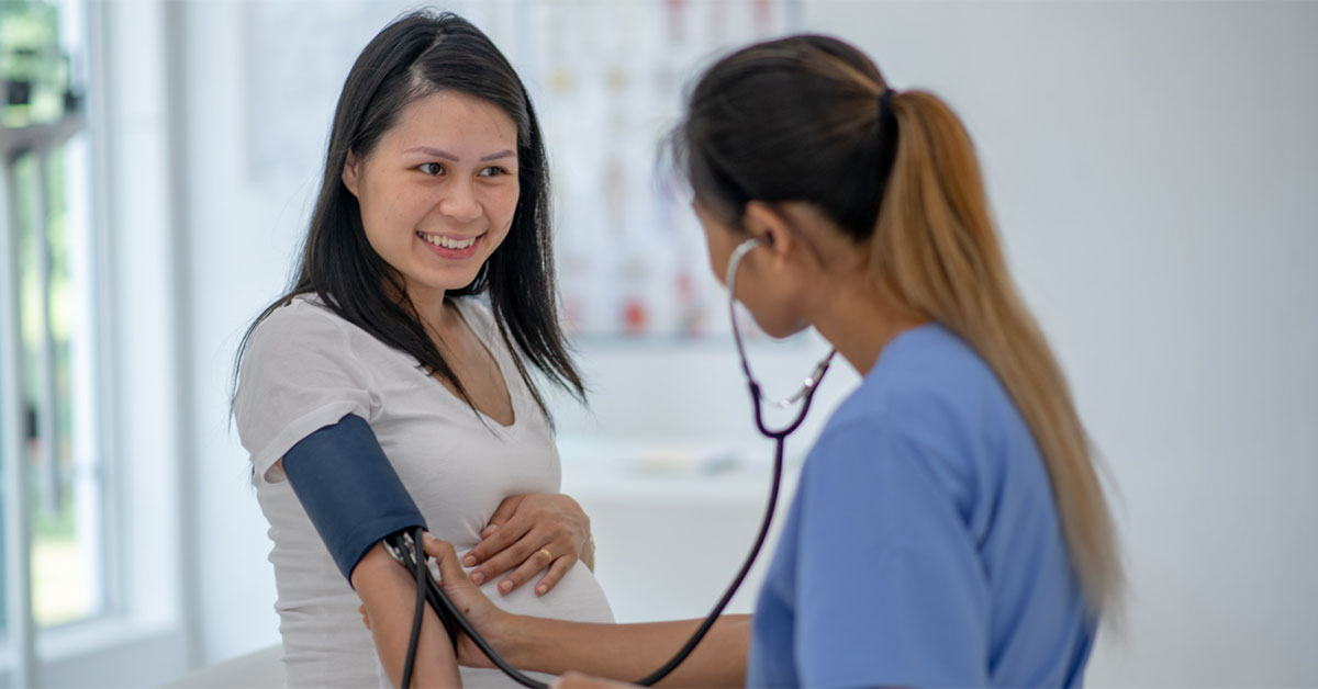 A female practice nurse tests the blood pressure of a pregnant patient