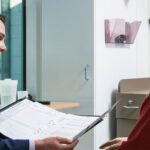 A male health professionals speaks with a middle aged male patient about a clinical trial
