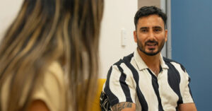 A man in his 30s speaks with a health professional about his mental health
