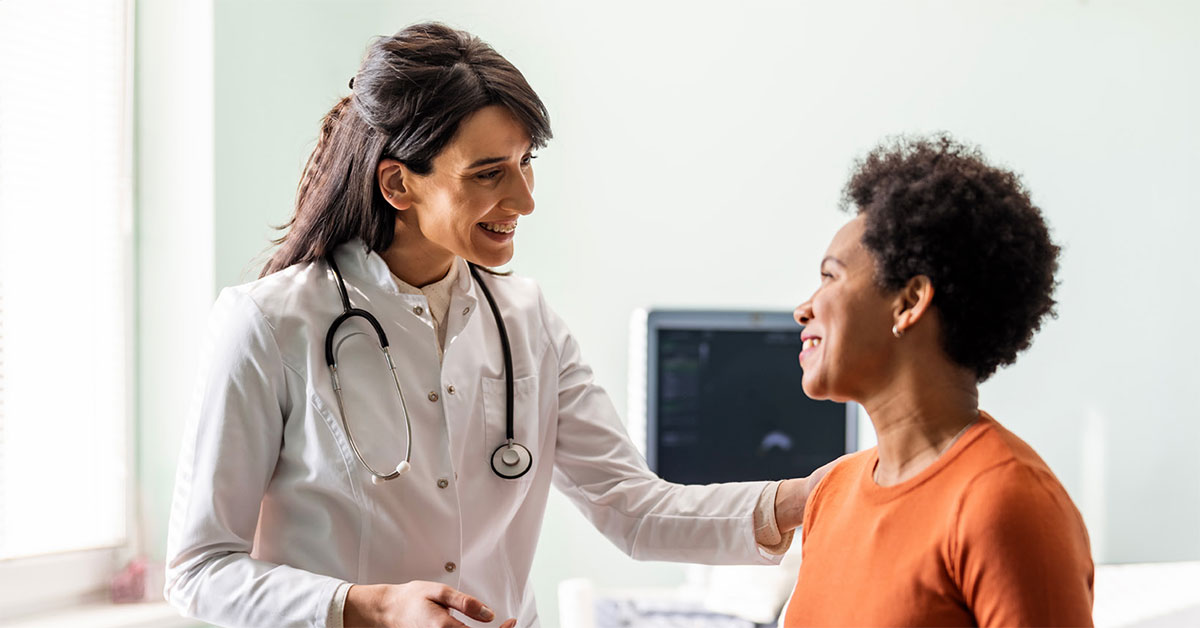 A female doctor speaks with a middle-aged female patient about lung cancer screening