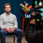 Dr Owen Harris speaks in front of a camera, as part of filming for the Raise It AOD stigma campaign