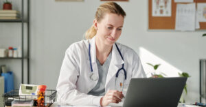A female clinician makes notes during a virtual call