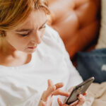 A female patient in her 30s looks at a prescription on her smartphone