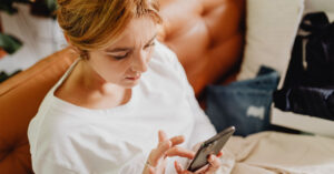 A female patient in her 30s looks at a prescription on her smartphone