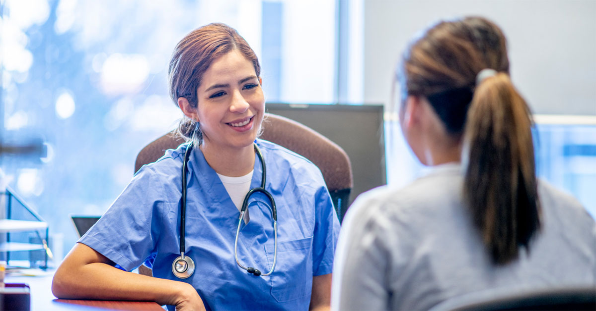 A young trainee doctor speaks with a patient.